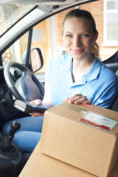 Female Courier In Van Delivering Package To Domestic House