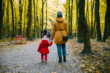 Fototapeta premium Little girl and her mother in the autumn park