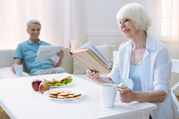 Exciting book. Pleasant morning for a pensioner with a book and her loving husband with a newspaper