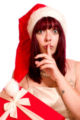 Junge Frau mit Nikolausmütze hält den Finger vor den Mund 