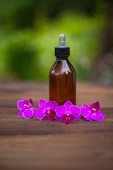 Essence of orchid flowers on table in beautiful glass jar