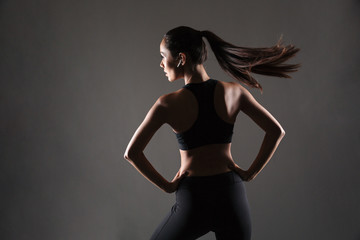 Back view portrait of a young fit woman standing