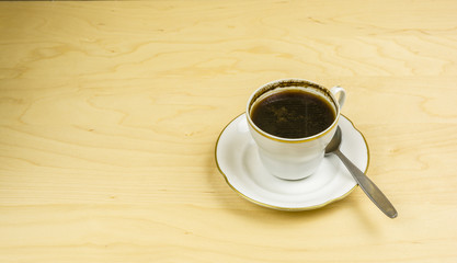 Brewed coffee in a white cup with a gold strip.