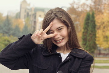 Portrait of a beautiful girl who has fun walking along the street