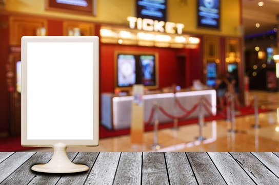mini blank advertising billboard with blurred image of ticket sales counter at movie theater, copy space for text or media content, advertisement, commercial and marketing concept