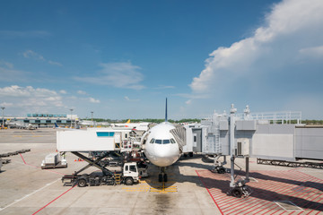 Airplane at airport terminal gate ready for takeoff. Modern international airport.