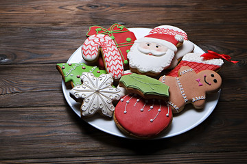 Plate full of tasty Christmas cookies on brown wooden table