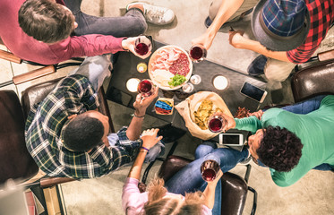 Fototapeta na wymiar Top view of multi racial friends tasting red wine and having fun at fashion bar winery restaurant - Multicultural friendship concept with people enjoying time drinking together - Indoor neutral filter