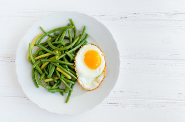 Cooked green beans with fried egg