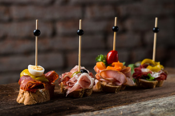 Tapas on Crusty Bread - Selection of Spanish tapas served on a sliced baguette. - obrazy, fototapety, plakaty