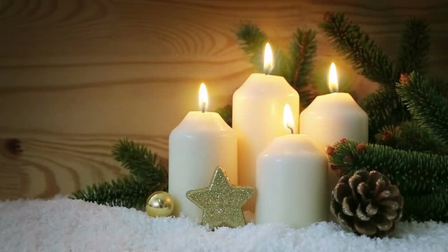 Four white advent candles and golden decoration.