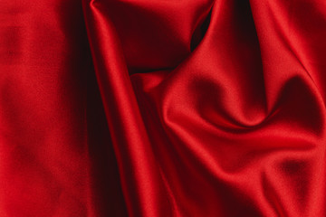 Red silky soft satin fabric with heart shape symbol background.