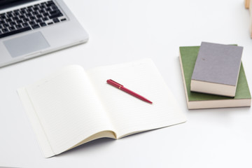 The office tool for work ,The blurry light design background of office tool for work ,laptop,book and  pen ,they are put on office deskop, mobile phone,paper work, pen ,they are put on office desk,