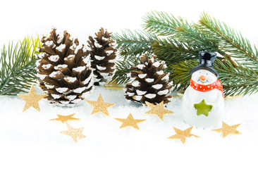 Golden glittering stars in the snow, with a snowman and fir cones and fir branch
