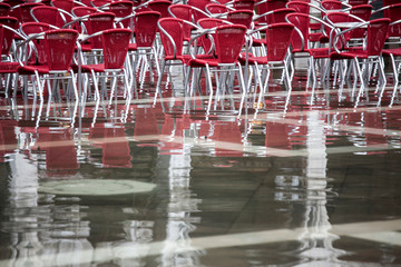 Cafe chairs in flooded St Mark's Square, Venice, Italy