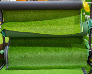 Selection of artificial lawn grass carpet in gardening store