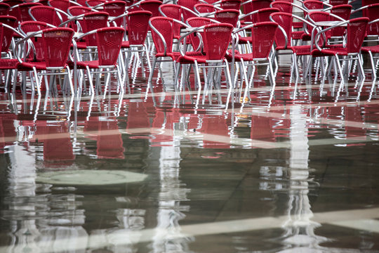 Cafe chairs in flooded St Mark's Square, Venice, Italy
