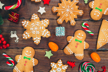 Christmas gingerbread cookies homemade on wooden table with candies and New Year decorations. Xmas background