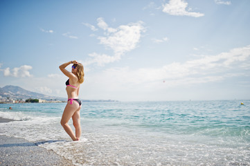 Fototapeta na wymiar Beautiful model relaxing on a beach dressed in a swimsuit.