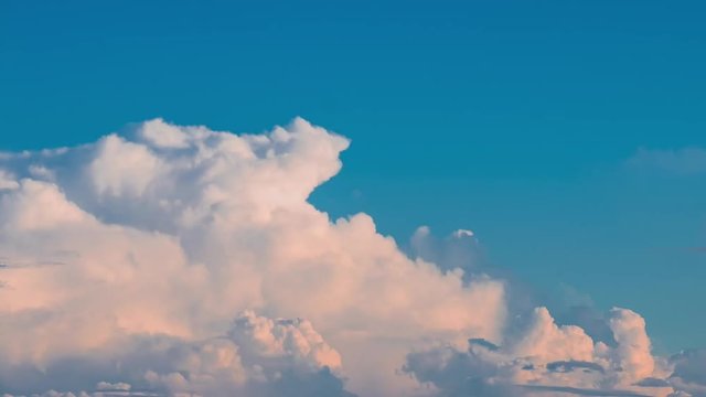 Timelapse, seamless, moving fluffy cloud over on the blue sky before sunset.