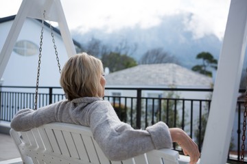 Thoughtful woman relaxing in porch
