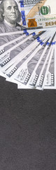 Veer of hundreds american dollars on a black background