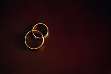 Gold wedding rings lie on a wooden table