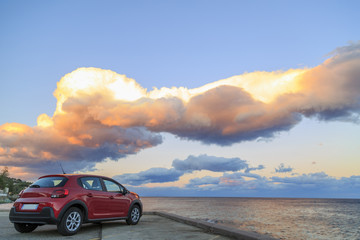 Fototapeta na wymiar A red car on a beach