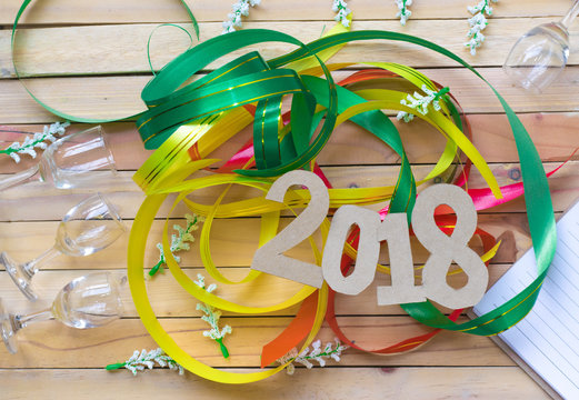 notepad with number paper 2018 and ribbon on wood background for happy new year image. And welcome new year photo.
