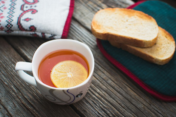 On wooden background, on the boards of toasted bread with tea and cakes