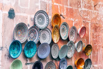 Fototapete Marokko colorful pottery plates hanging at wall,