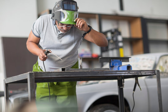 Man welding in bodywork repair shop