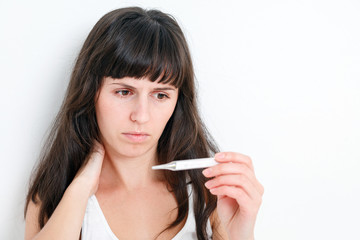 Sick Woman looking at thermometer