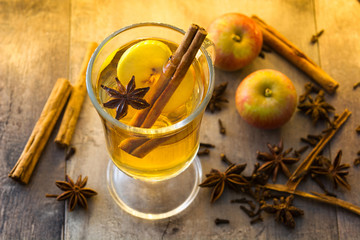  Mulled cider in glass on wooden table. Christmas drink