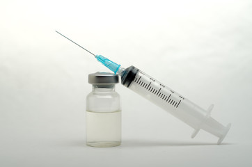 A medical syringe recruits a vaccine from an ampoule