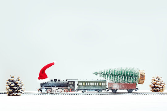 Xmas Toy Train In Snow With Xmas Tree On Board. Christmas, New Year Travel Concept.