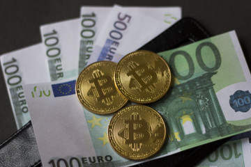 Golden bitcoins and banknotes Euro in my wallet on a black background. the new virtual money