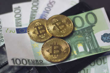 Golden bitcoins and banknotes Euro in my wallet on a black background. the new virtual money