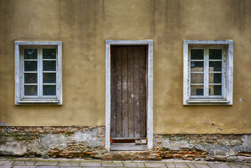 Old two windows and door with grunge cracked wall