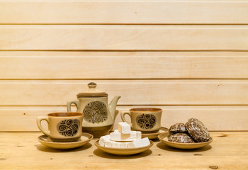 Pastry and tea-set on wooden background