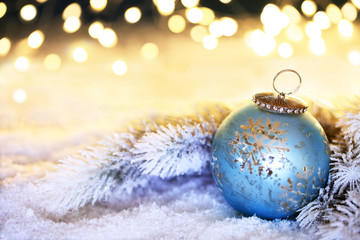 blaue Weihnachtskugel vor funkelndem Hintergrund
