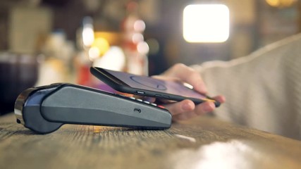 Payment made with smartphone using nfc system and contactless card. - Powered by Adobe