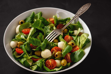 Salad with tomatoes, mozarella and olives.