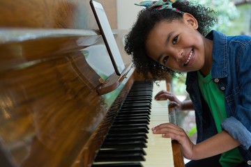 Girl playing piano with digital tablet © wavebreak3