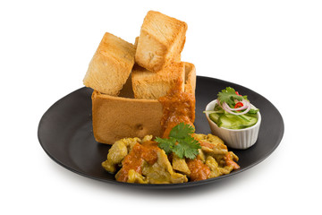 Pork satays with peanut sauce and pickles which are cucumber slices and onions in vinegar served with toast