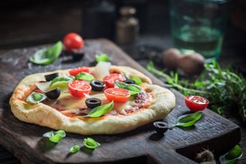 Homemade pizza made of cheese, tomatoes and herbs