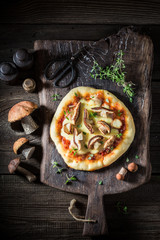 Hot and fresh rustic pizza with noble mushrooms and thyme