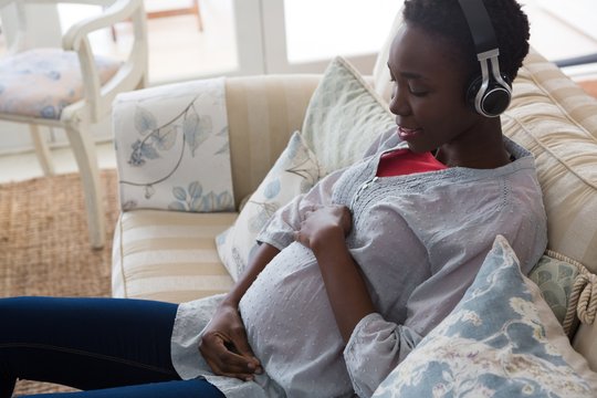Pregnant woman listening music on headphones