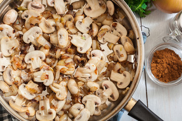 Mushrooms and onion on a fried pan