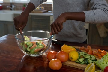 Mid section of woman preparing salad